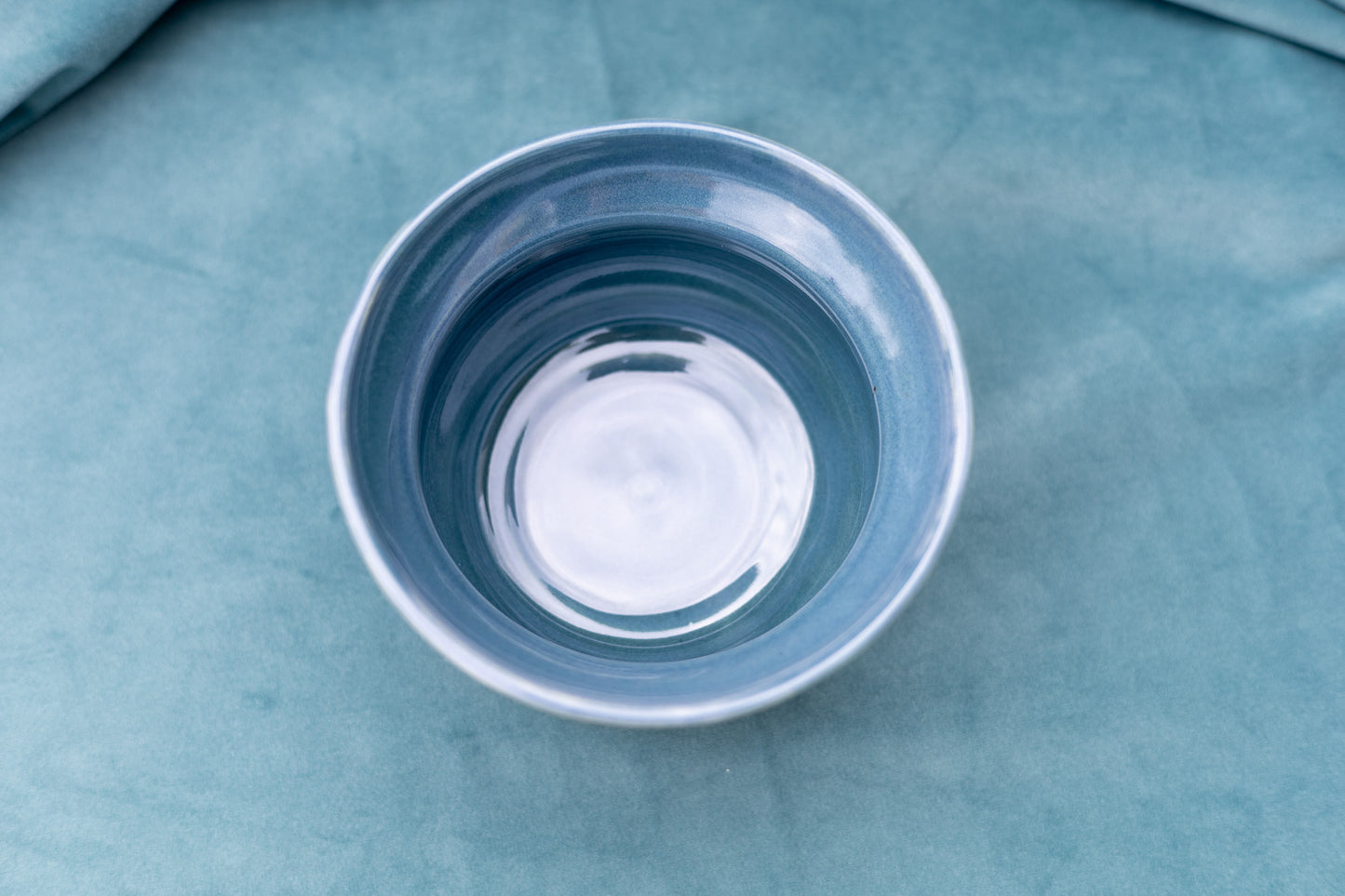 Blue ceramic bowl on a textured blue surface