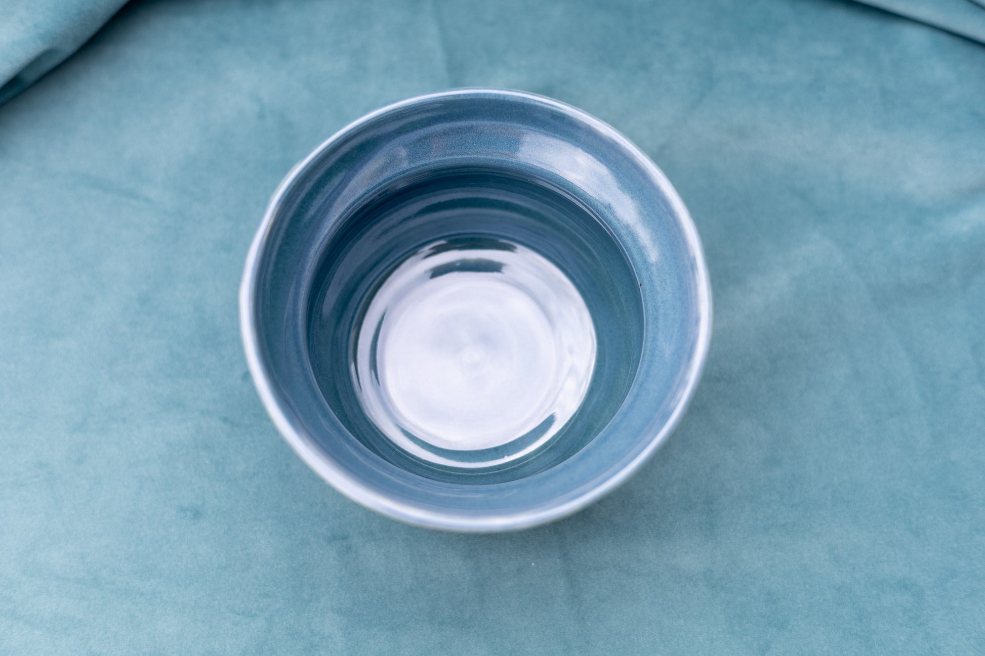 Blue ceramic bowl on a textured blue surface